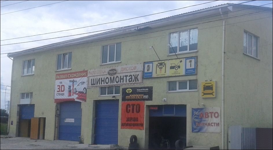 Будівля з вивісками СТО та шиномонтажу на вулиці Київській