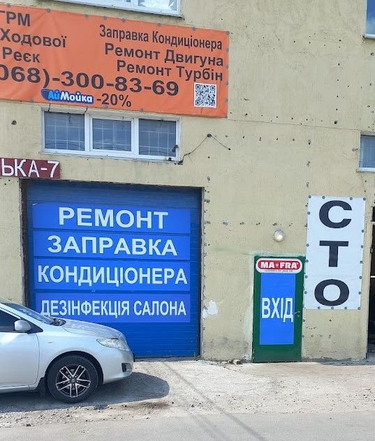Вхід у бокси СТО з номером телефону на вивісці