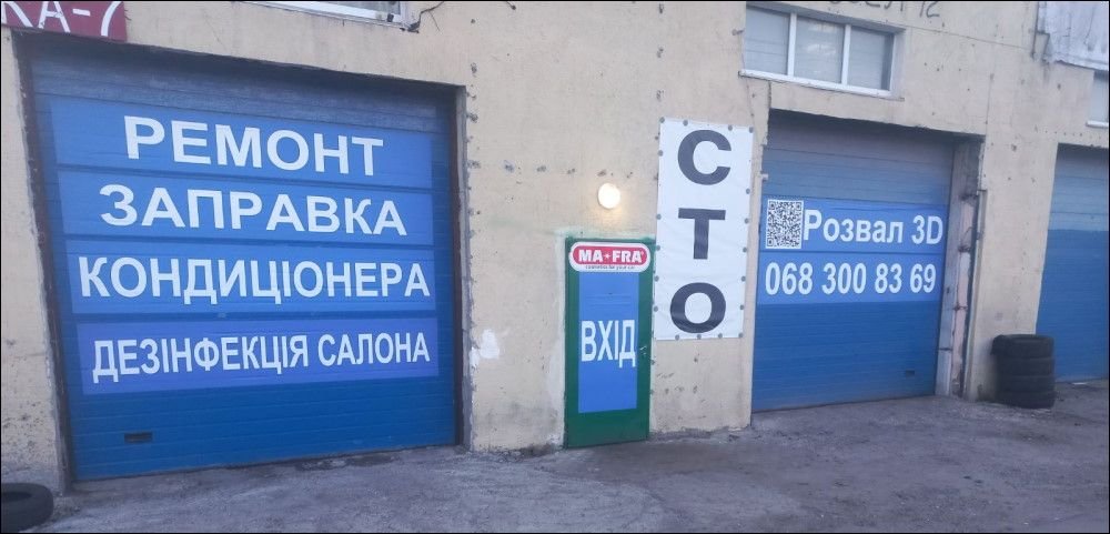 Ворота боксів СТО з написами «Ремонт, заправка кондиціонера» та «СТО»
